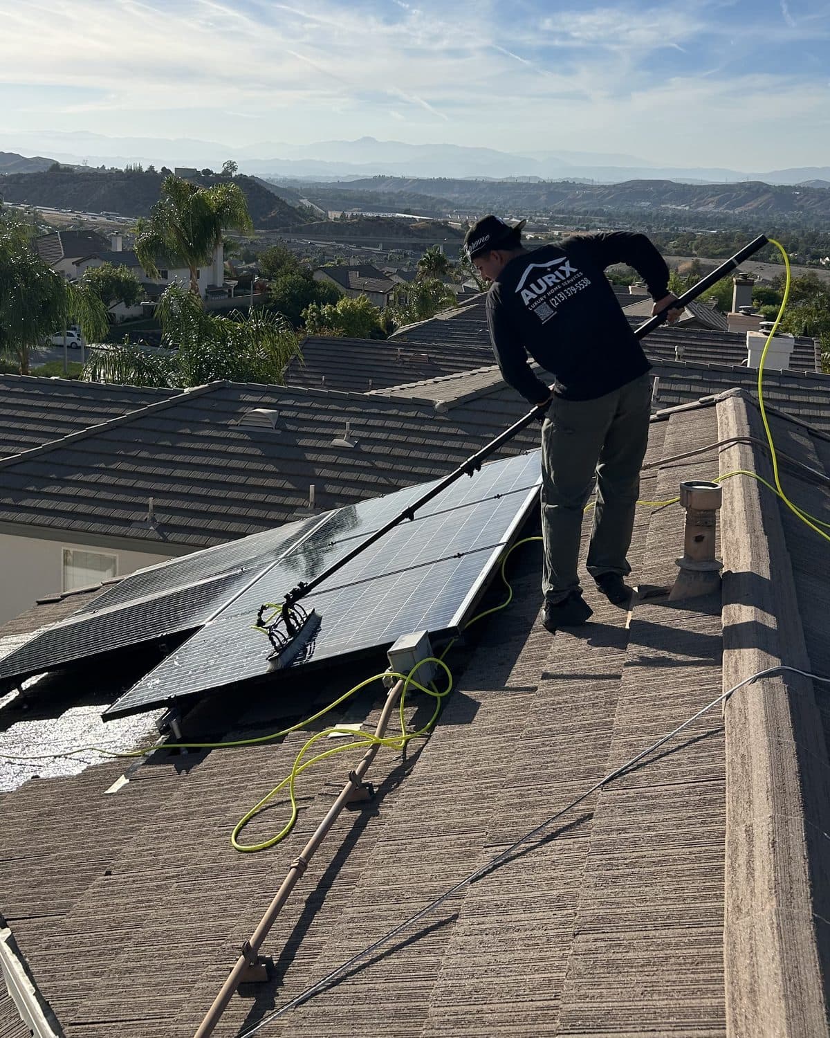 An Aurix technician cleaning a residential solar array in Palmdale